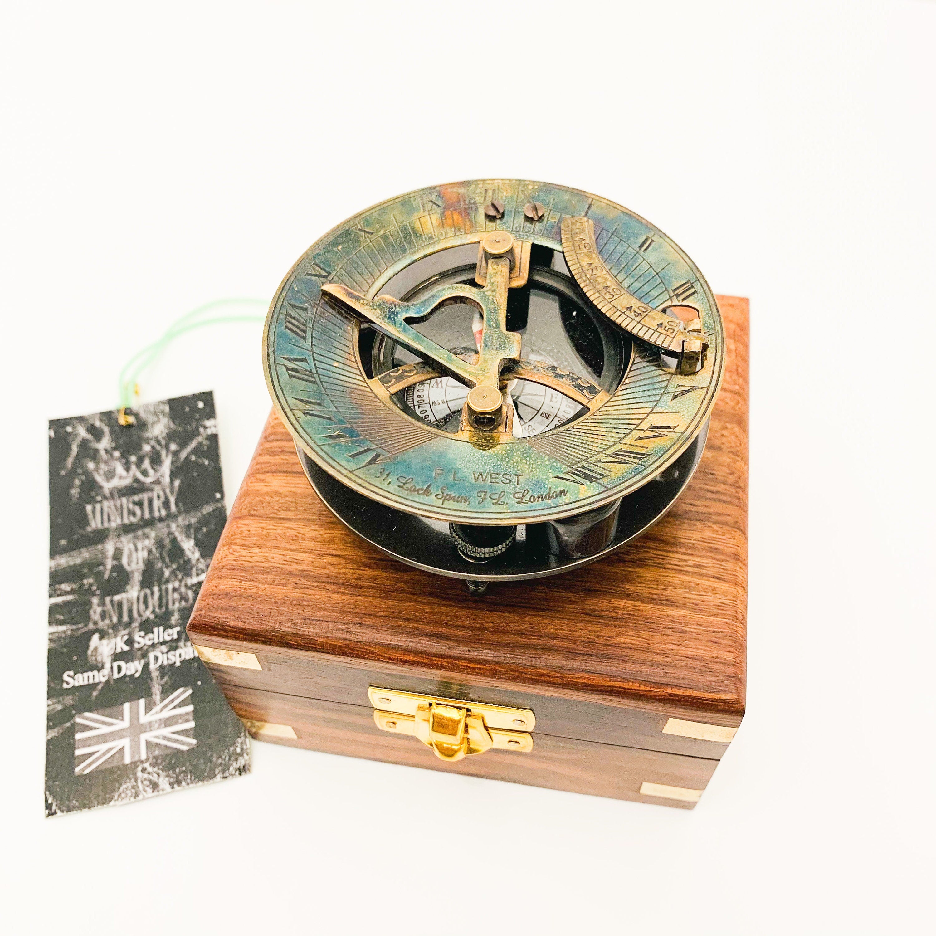 Peut inclure: Un compas de soleil en laiton avec une boîte en bois. Le compas a une finition bleue, verte et dorée. La boîte est en bois foncé avec des accents en laiton. Le compas porte l'inscription "31,  Leach  Spur  72,  London".