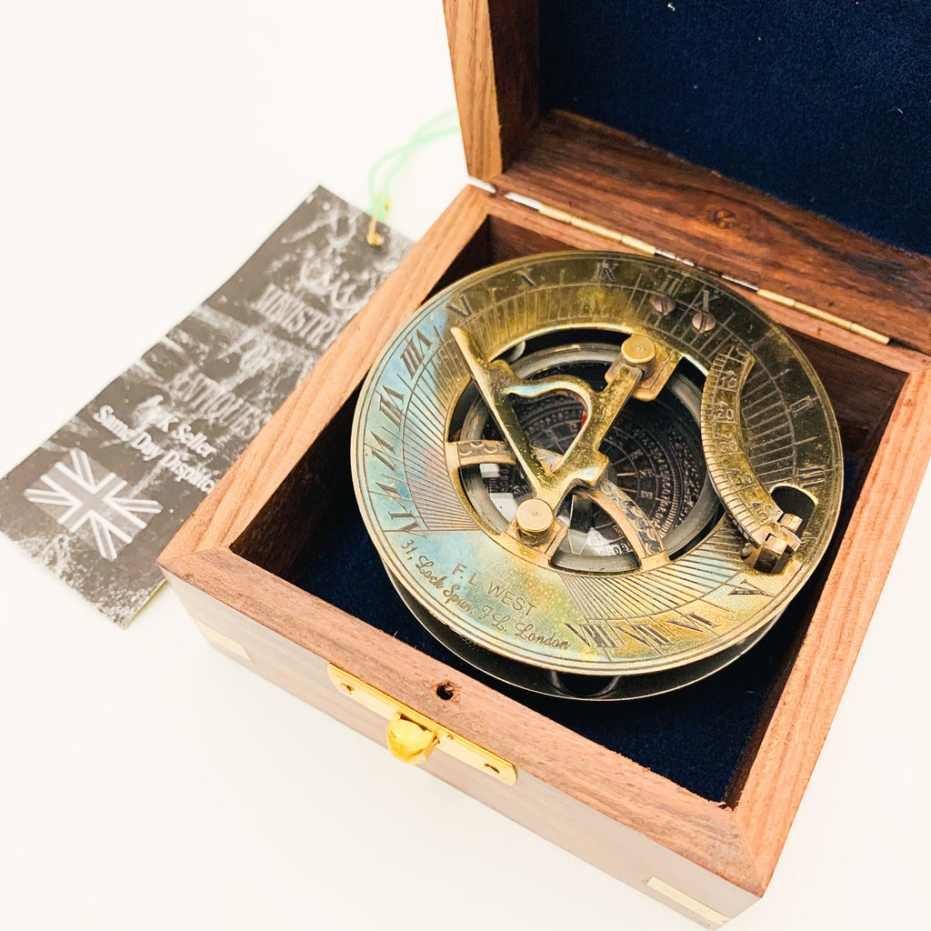 Peut inclure: Un cadran solaire en laiton avec une boussole dans une boîte en bois. Le cadran solaire comporte des chiffres romains et une rose des vents. La boîte est en bois foncé avec un loquet en laiton.