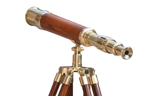 May include: A vintage telescope with a wooden barrel and brass detailing. It is mounted on a brass tripod with wooden legs. The design evokes a classic nautical theme, suggesting a focus on exploration and observation. The telescope is a decorative item.